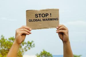 stänga upp händer håll papper kort med ord sluta global uppvärmning. begrepp, kampanj människor runt om de värld till sluta aktiviteter den där kan orsak global uppvärmning. miljö bevarande. foto