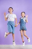 porträtt av två asiatiska flickor på lila bakgrund foto