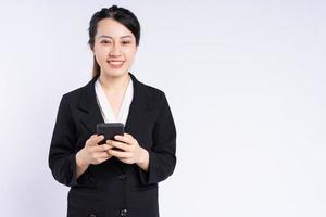ung asiatisk affärskvinna som använder smartphone på vit bakgrund foto