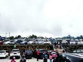 boyolali, Indonesien. april 29, 2023. stor parkering område på de cepogo ost parkera turist attraktion på helger eller högtider. de parkering massa är mycket belastad och upptagen. molnig himmel med vit moln. foto