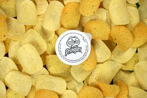 pringles logotyp på papper membran på många orange pringles potatis mellanmål pommes frites. pringles är en varumärke av potatis mellanmål pommes frites ägd förbi kellogg företag foto