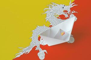 bhutan flagga avbildad på papper origami fartyg närbild. handgjort konst begrepp foto