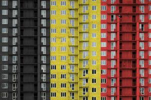 belgien flagga avbildad i måla färger på flera våningar bosatt byggnad under konstruktion. texturerad baner på tegel vägg bakgrund foto