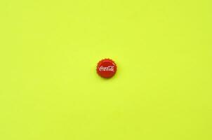 enda röd flaska lock med coca cola logotyp på gul bakgrund foto