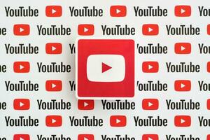 Youtube logotyp klistermärke på mönster tryckt på papper med små Youtube logotyper och inskriptioner. Youtube är Google dotterföretag och amerikan mest populär videodelning plattform foto