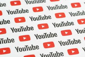 Youtube mönster tryckt på papper med små Youtube logotyper och inskriptioner. Youtube är Google dotterföretag och amerikan mest populär videodelning plattform foto