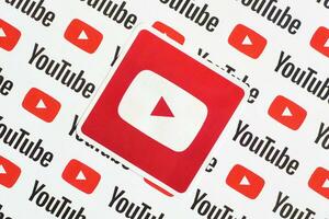 Youtube logotyp klistermärke på mönster tryckt på papper med små Youtube logotyper och inskriptioner. Youtube är Google dotterföretag och amerikan mest populär videodelning plattform foto