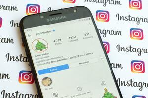 Precis inkommet bieber officiell Instagram konto på smartphone skärm på papper Instagram baner. foto