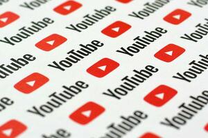 Youtube mönster tryckt på papper med små Youtube logotyper och inskriptioner. Youtube är Google dotterföretag och amerikan mest populär videodelning plattform foto