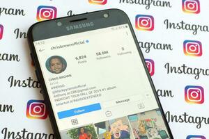 Chris brun officiell Instagram konto på smartphone skärm på papper Instagram baner. foto