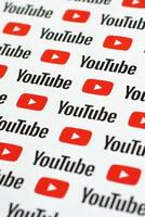 Youtube mönster tryckt på papper med små Youtube logotyper och inskriptioner. Youtube är Google dotterföretag och amerikan mest populär videodelning plattform foto