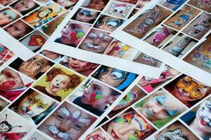 många katalog sidor med tryckt barn porträtt med färgrik ansikte målning foto