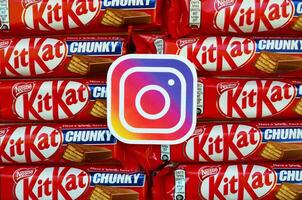 Instagram papper logotyp på många utrustning kat choklad täckt rån barer i röd omslag. reklam choklad produkt i Instagram social nätverk och värld bred webb foto