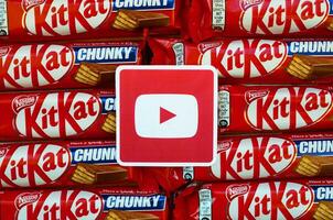 Youtube papper logotyp på många utrustning kat choklad täckt rån barer i röd omslag. reklam choklad produkt i Youtube social nätverk och värld bred webb foto