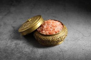 himalayan rosa salt i gyllene låda i köket foto