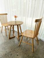 de trä- stol och tabell uppsättning i de minimal stil med de blomning blomma. foto