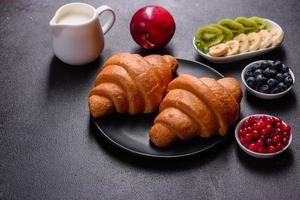 utsökt frukost med färska croissanter och mogna bär