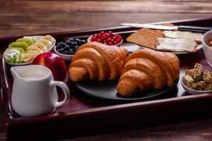 utsökt frukost med färska croissanter och mogna bär foto