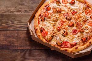 välsmakande skivad pizza med skaldjur och tomat på en betongbakgrund
