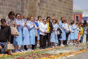 puebla, mexico 2023 - präster och medlemmar av de katolik kyrka bära ut en procession i främre av de katedral av puebla. dyrkan av katolik kristen symboler foto