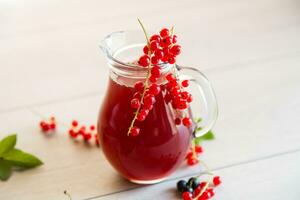 färsk bär juice från röd och svart vinbär, på en trä- tabell foto