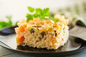 kokta kokt ris med zucchini, morötter och grönsaker i en tallrik foto