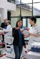 ung asiatisk kvinna återvändande fel vitamin paket i apotek, be farmaceutisk konsult till utbyta diet- tillskott låda. kund som visar kemist multivitamin komponenter på flaska foto