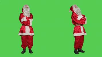 santa claus ordspråk ho ho ho i studio, spridning festlig Semester anda under jul eve. man porträtterar helgon nick med ikoniska kostym med hatt och vit skägg, Framställ på full kropp grönskärm. foto