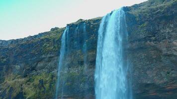 skön vattenfall i reykjavik island med vatten strömmande av klippor och kullar, Seljalandsfoss kaskad med flod ström. majestätisk isländsk landskap och vildmark, spektakulär landskap. foto