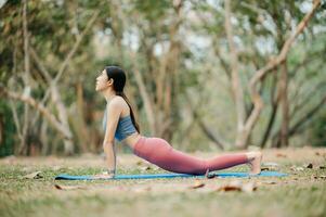 porträtt av ung kvinna praktiserande yoga i trädgård.kvinna lycka. i de parkera suddig bakgrund. friska livsstil och avslappning begrepp foto