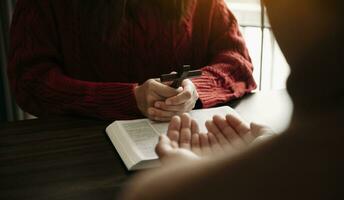 två människor läsning och studie bibel i Hem och be tillsammans.studerar de ord av Gud med vänner. i Sol ljus foto