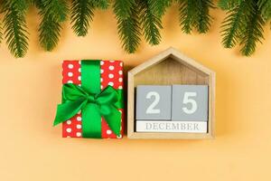 topp se av trä- kalender, gåva låda och gran träd på färgrik bakgrund. de tjugo femte av december. jul tid med kopia Plats foto
