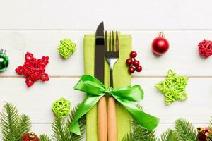 topp se av jul dekorationer på trä- bakgrund. gaffel och kniv på servett bunden upp med band och tömma Plats för din design. ny år mönster begrepp foto