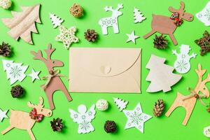 jul grön bakgrund med Semester leksaker och dekorationer. topp se av hantverk kuvert. Lycklig ny år begrepp foto