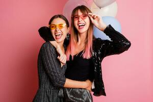 två kvinnor , bäst vänner fira höna fest, Framställ med brud- Foto rekvisita på rosa bakgrund.