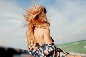 sorglös kvinna Hoppar frihet på vit sand. blå hav bakgrund. blåsigt hårstrån. foto