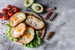 utsökt frukost med grymtande, ägg, avokado och körsbärstomater foto