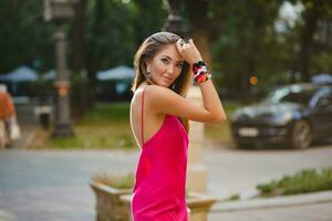 elegant attraktiv kvinna bär rosa sexig sommar klänning gående i gata foto