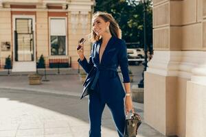 elegant attraktiv kvinna bär blå eleganta kostym gående i gata foto