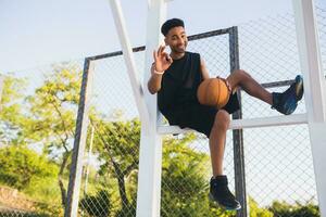 svart man håller på med sporter, spelar basketboll på soluppgång, aktiva livsstil, solig sommar morgon- foto