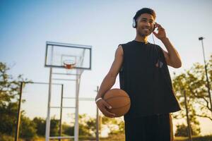 svart man håller på med sporter, spelar basketboll på soluppgång, aktiva livsstil, solig sommar morgon- foto