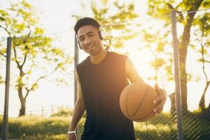 svart man håller på med sporter, spelar basketboll på soluppgång, aktiva livsstil, solig sommar morgon- foto