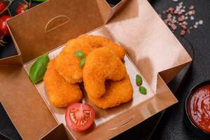 utsökt färsk Krispig kyckling nuggets på en mörk betong bakgrund foto