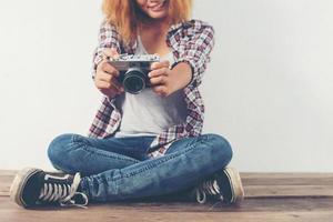 ung hipsterfotografkvinna som tar foto och tittar på kameran