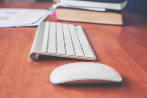 trådlöst tangentbord, mus på träbordet för affärsperson. foto