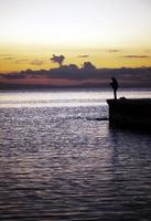 en ensam man siluett nära havet foto