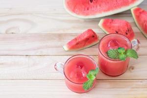 vattenmelonskiva dricka juice på träbord