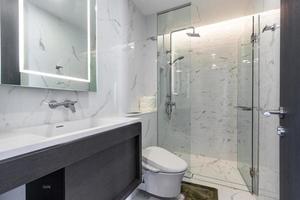 vit modern och trä badrum med duschkabin glas i lägenheten foto