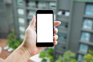 mockupbild av man som håller smartphone med tom vit skärm. foto