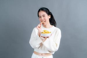ung asiatisk kvinna äter potatischips foto